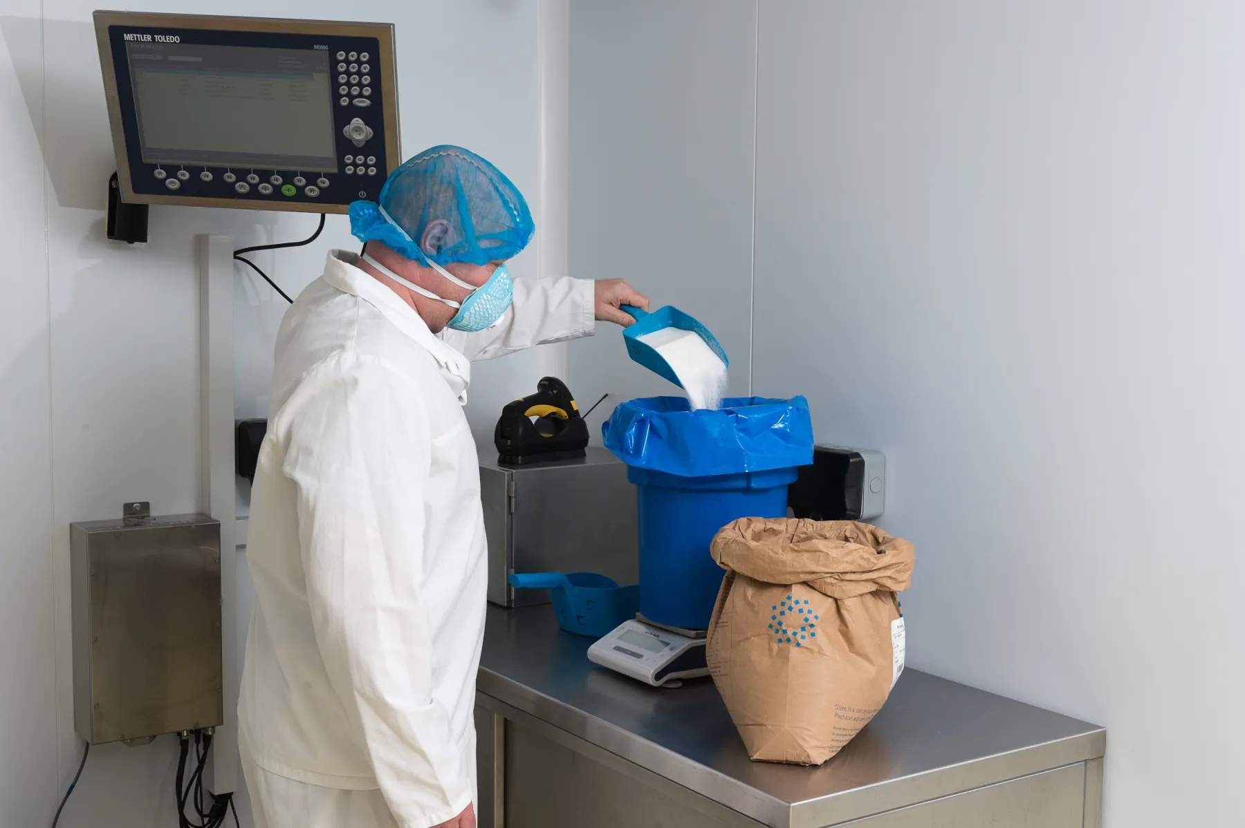 Team member weighing a powder ingredient during production